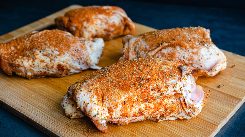 raw chicken thighs with dry rub on.