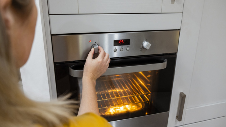 woman adjusting settings on home oven