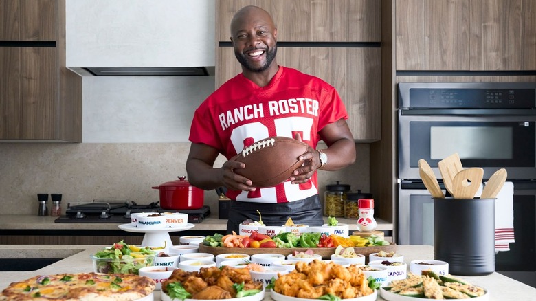 Eddie Jackson posing behind kitchen counter filled with food