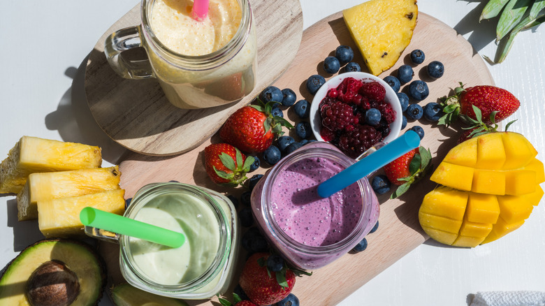 overhead view of smoothies with fruit and straws