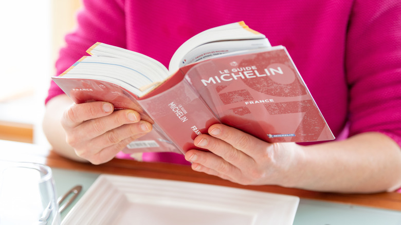 someone reads a Michelin Guide book