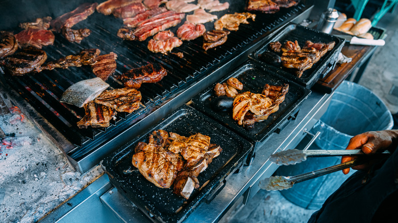 different cuts of meat on a large grill