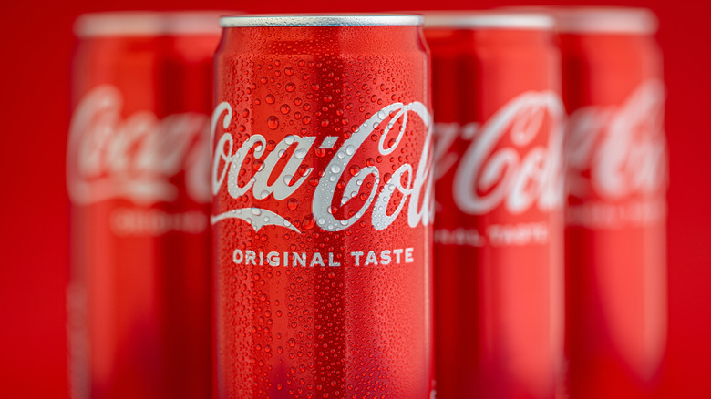 Close-up of four Coca-Cola cans