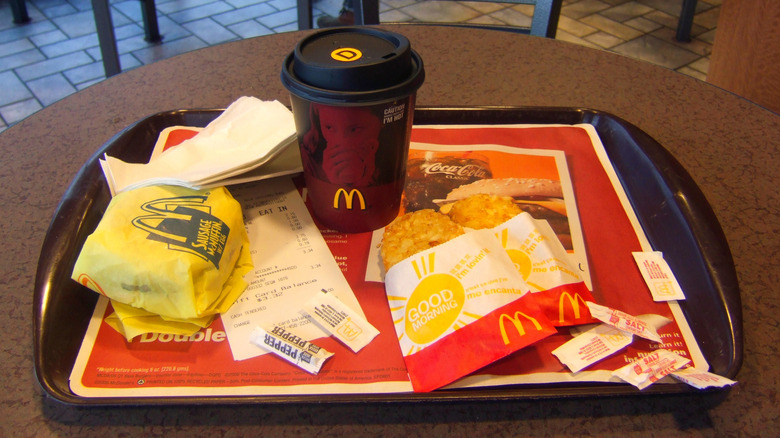 McDonald's breakfast featuring a coffee, hashbrowns and a sandwich