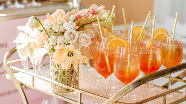 A bar cart of prepped Aperol sptrizes