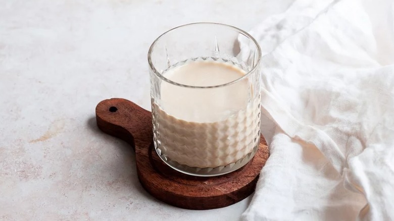 View of White Russian cocktail in a glass on a wooden coaster