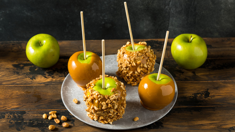 Caramel apples with nuts arranged on a tray