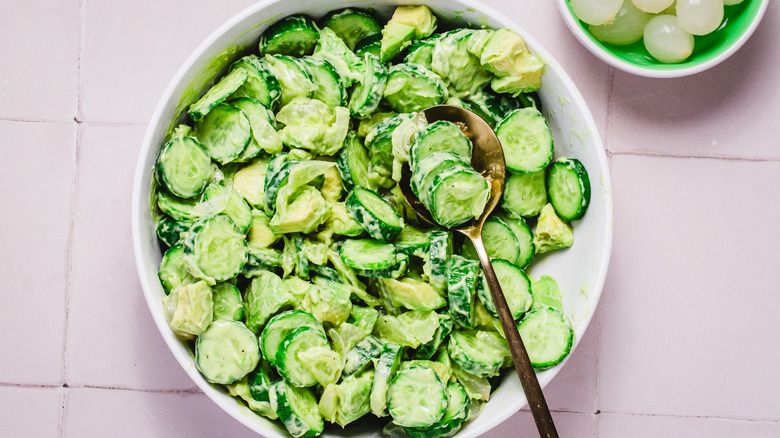 Bowl of avocado cucumber salad with spoon