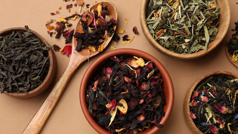 Different dried tea leaves in small bowls