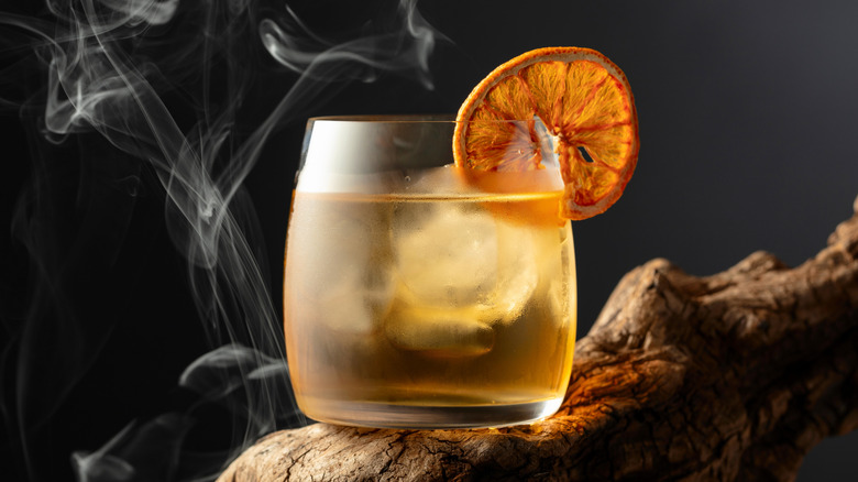 Old Fashioned cocktail on branch with smoke