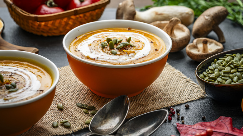 Vegetarian Thanksgiving soup with cream surrounded by ingredients and spoons