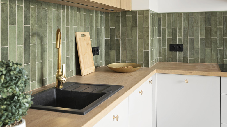Wooden kitchen countertops accompanied by green backsplash