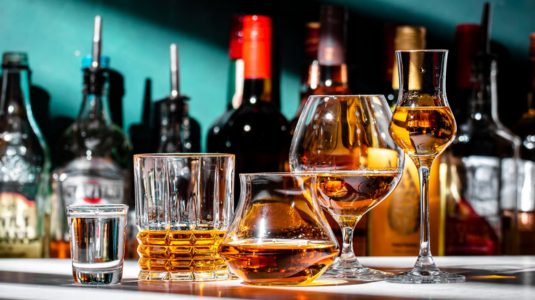 Amber-colored booze poured into various shaped glasses