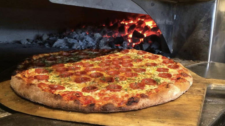 pizza cooking in coal oven