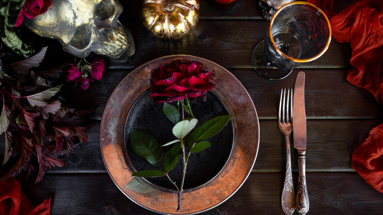 Dinner place setting with rose, skull, goblet, and creepy decor