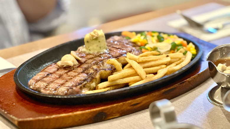 steak dinner at restaurant with fries and vegetables