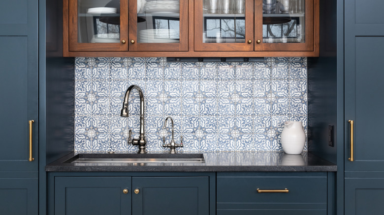 Kitchen interiors with patterned backsplash, granite countertops and chrome faucet