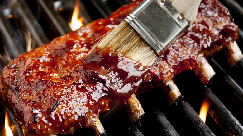 Brushing sauce on grilled ribs