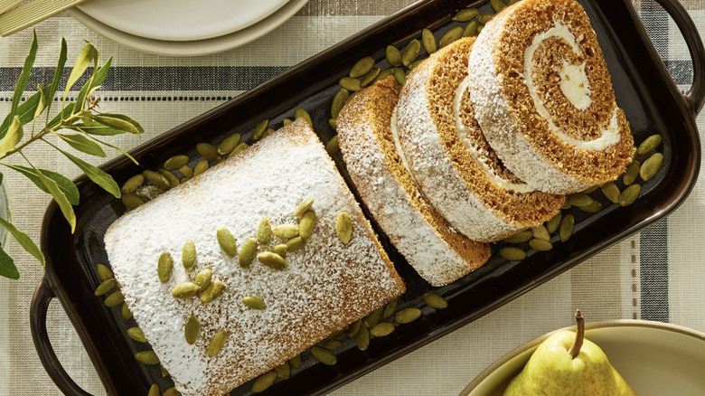 Walmart Freshness Guaranteed Pumpkin Cake Roll garnished with pumpkin seeds in black dish