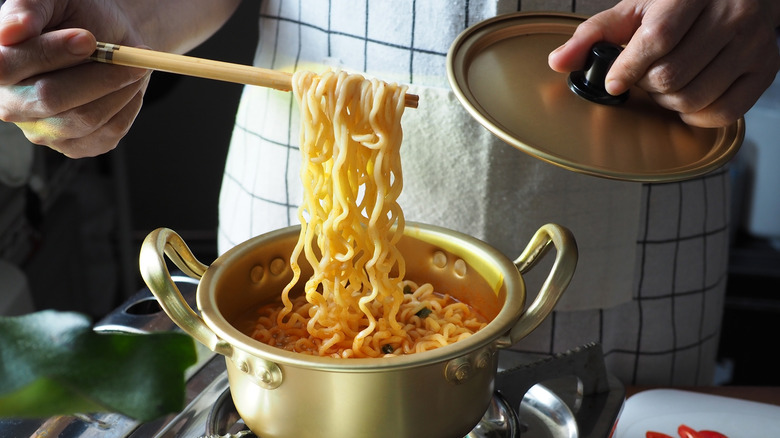 person cooking soup on stovetop