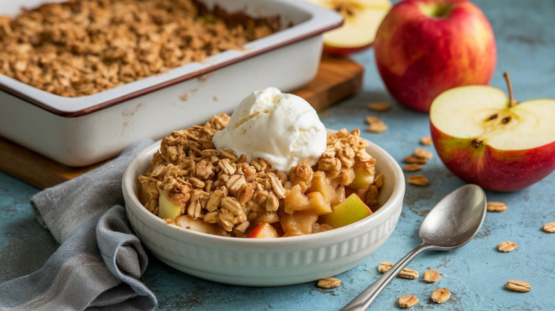 Apple crisp in a white bowl with a scoop of ice cream