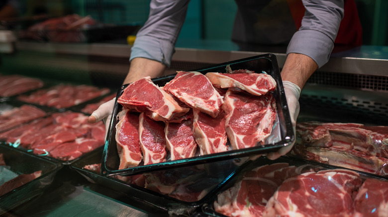 Multiple thick cut steaks with butcher holding tray