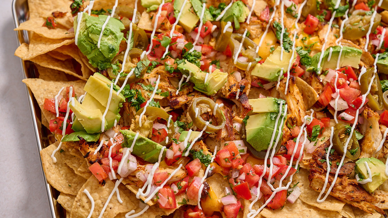 loaded chicken nachos on a sheet tray