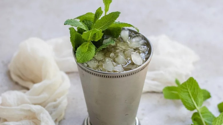 Iced mint julep in a chilled metal cup with mint garnishes