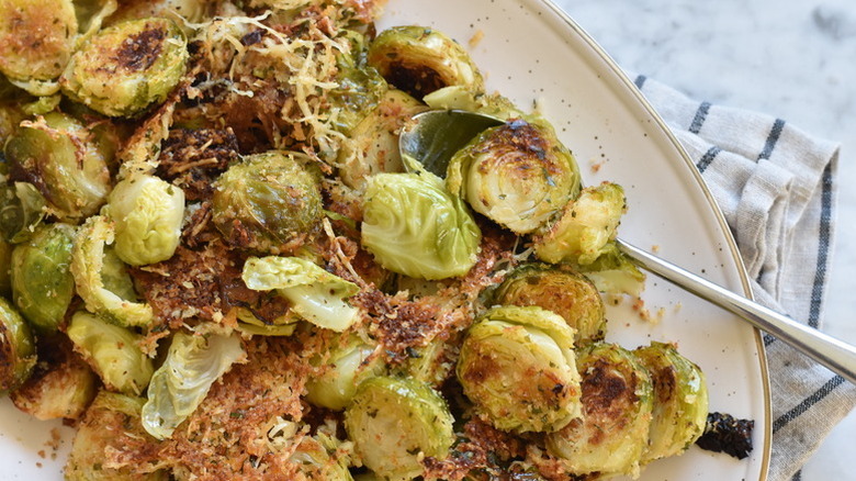 Parmesan-crusted Brussels sprouts in serving dish with spoon