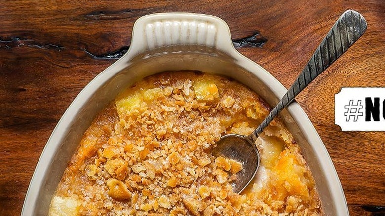 Pineapple cheese casserole in baking dish with spoon