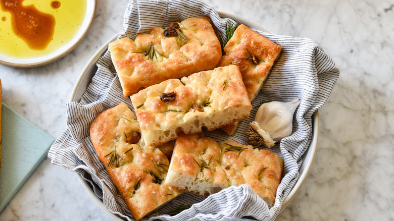 Slices of garlic and rosemary focaccia in a linen-lined bowl