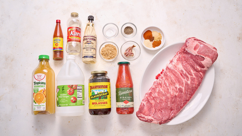 uncooked rack of spare ribs, seasoning, and other ingredients on a table