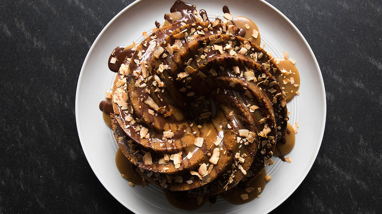 Bundt cake topped with caramel sauce, chocolate sauce, and shredded coconut