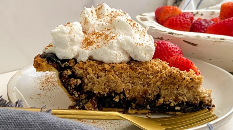 Slice of shoofly pie with strawberries and whipped cream