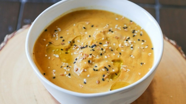 Bowl of spiced sweet potato soup topped with sesame seeds