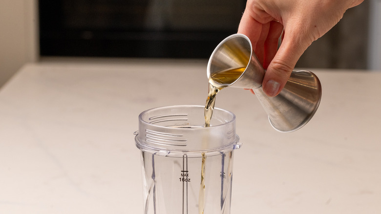 Pouring rum into a blender