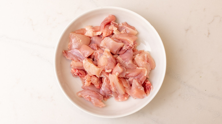 bowl containing chopped chicken thighs