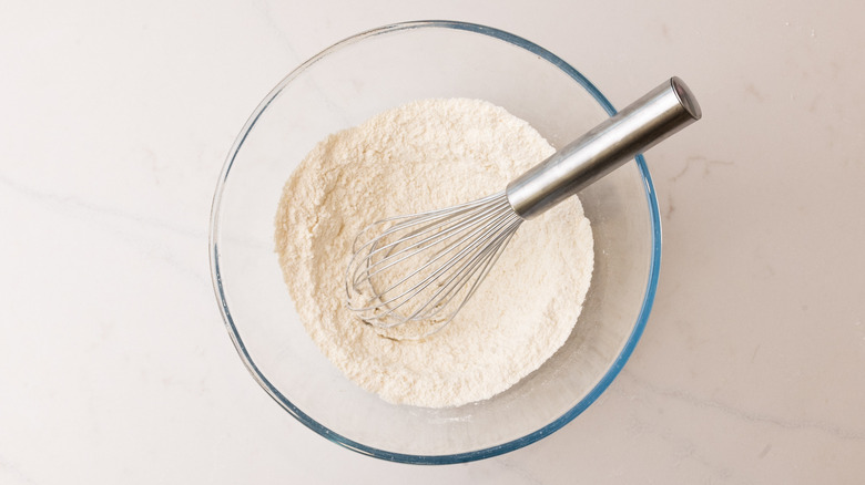 dry ingredients mixed together in glass bowl with whisk