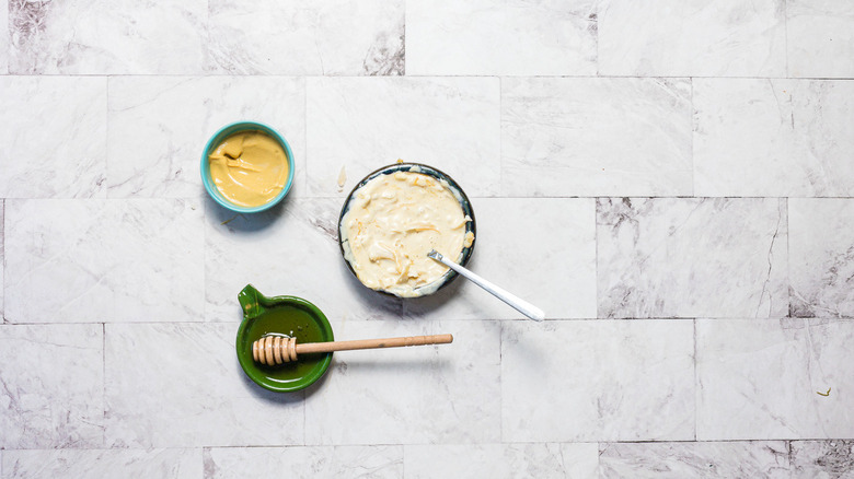 Bowl of sauce, with mustard and honey bowls beside it