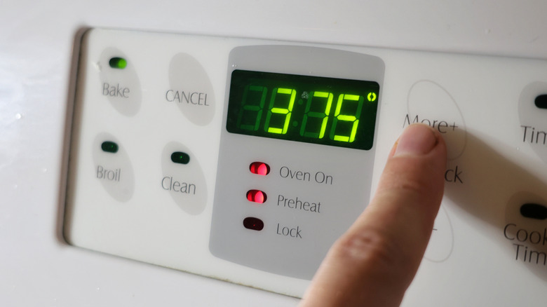 finger pressing oven button beside screen reading 375 degrees