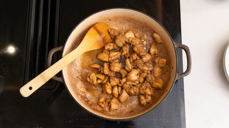 marinaded chicken frying in pan
