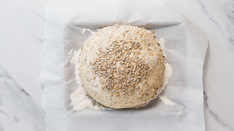 Seed covered dough on parchment paper