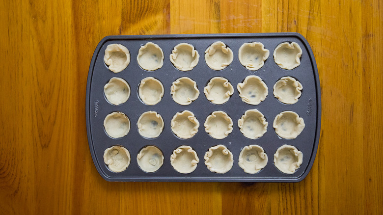muffin tin lined with dough