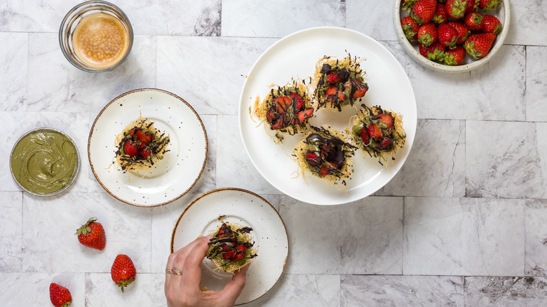 Dubai chocolate strawberry cups on plates