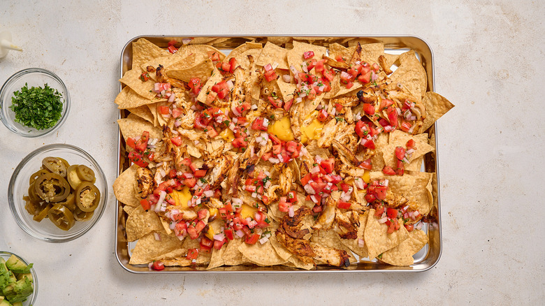 adding pico de gallo to nachos