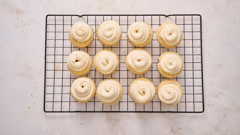 piping frosting onto each cupcake
