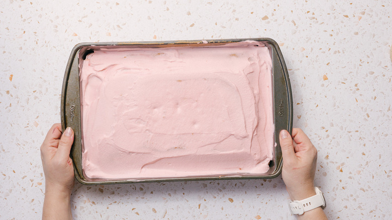 Hands holding pink cake