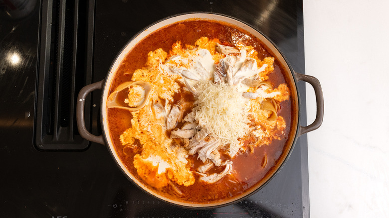 adding ingredients to soup