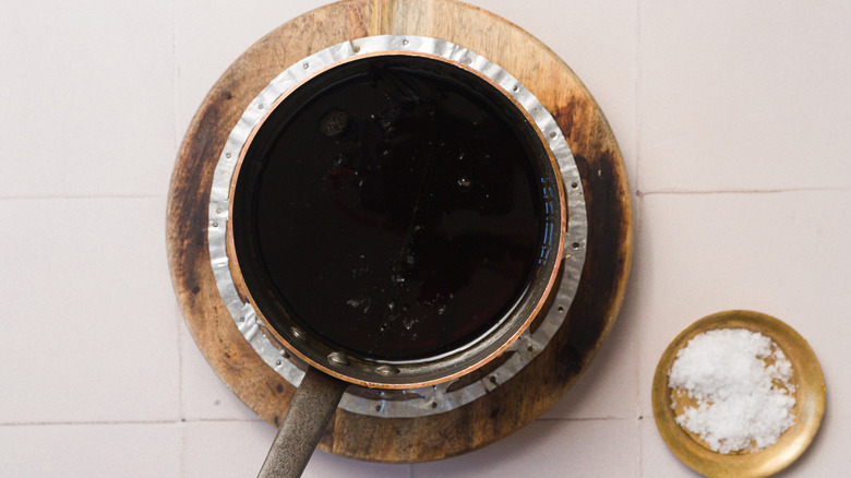 saucepan of brown sugar syrup next to a bowl of salt