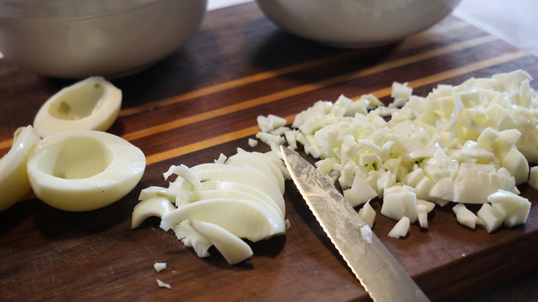 diced boiled egg whites on a cutting board beside a knife and whole boiled egg whites